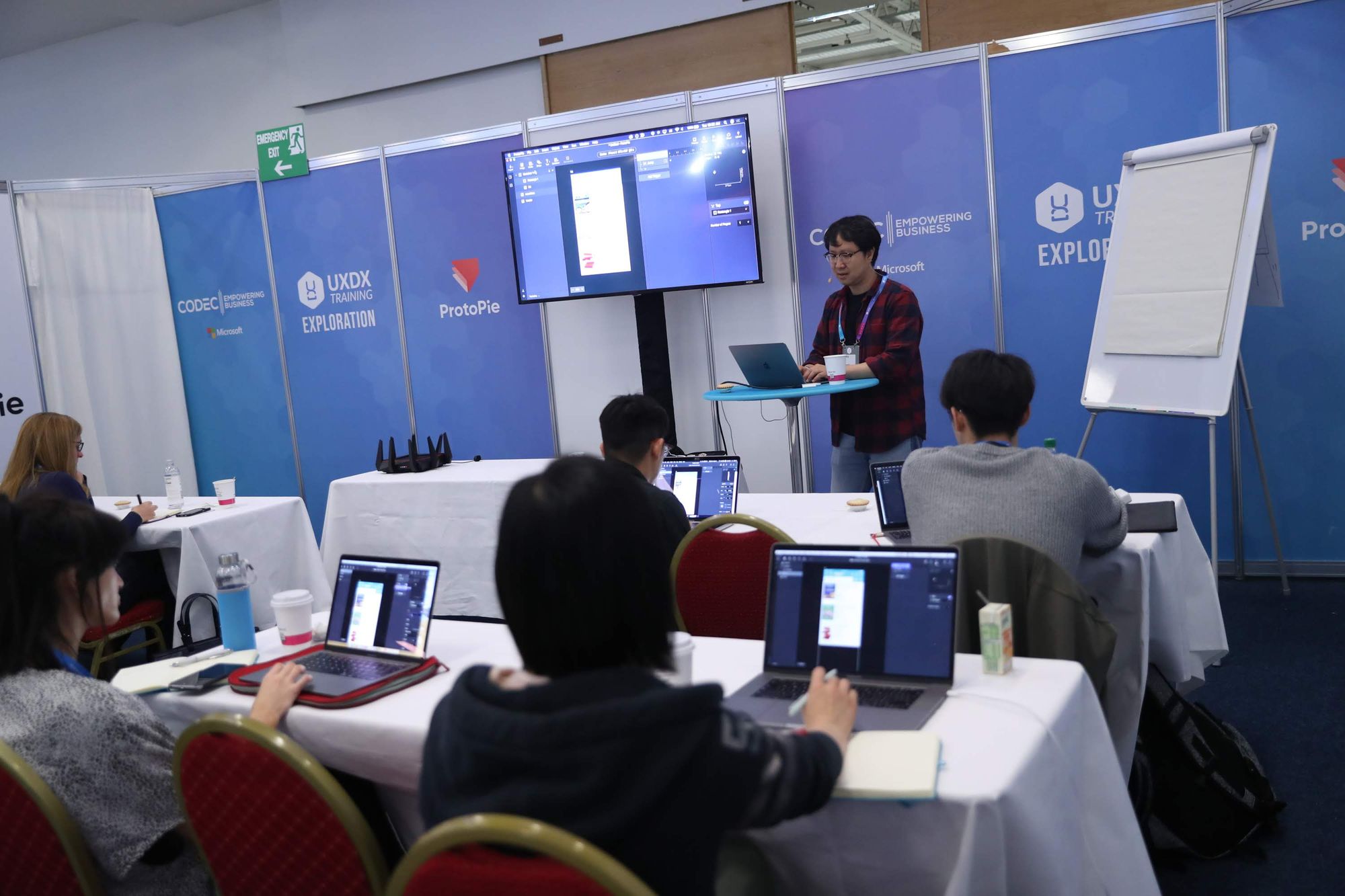 A hybrid workshop. People in the room but on laptops. The speaker presenting but on the laptop.